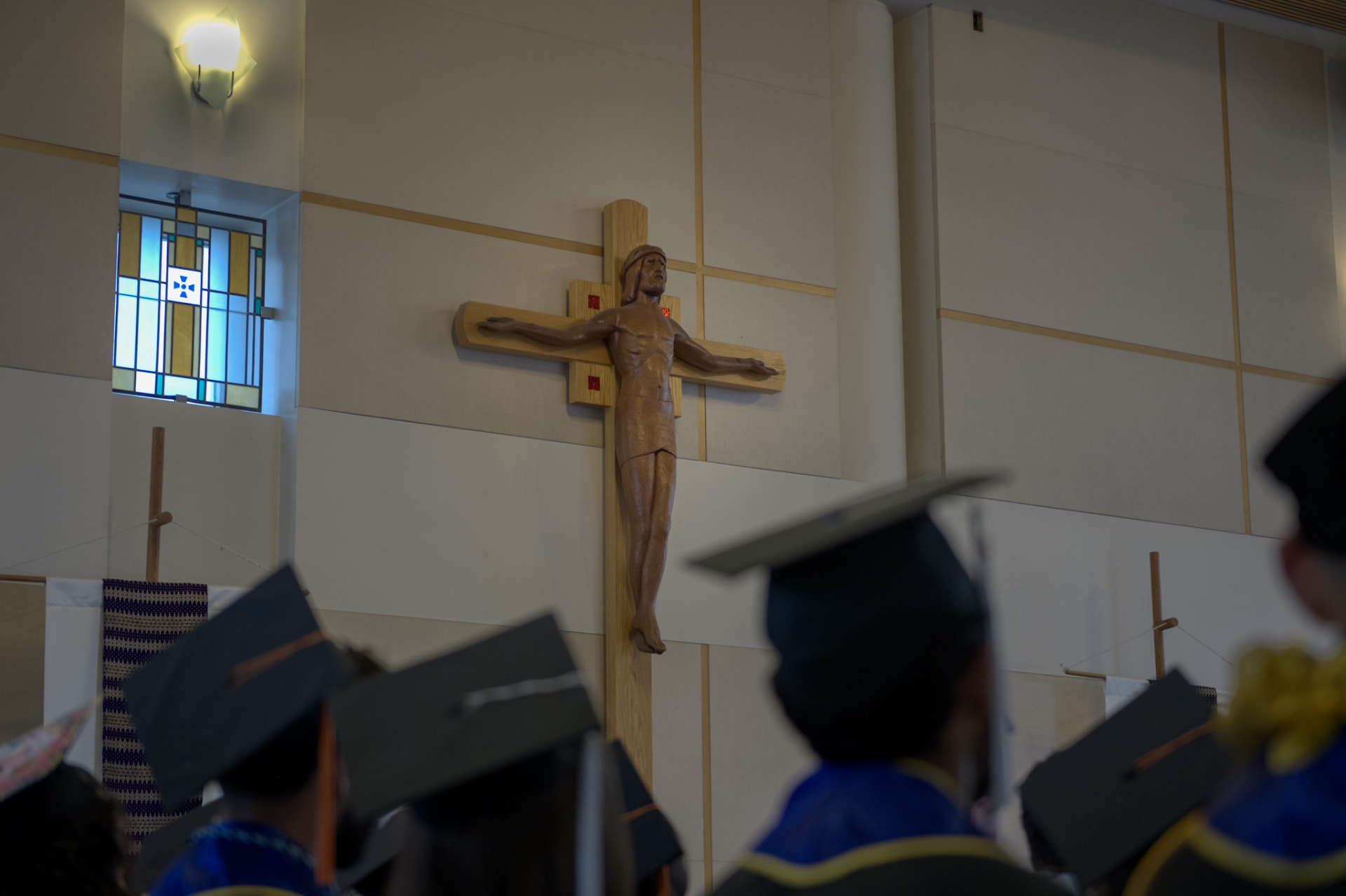 Crucifix above graduates in caps during the ceremony