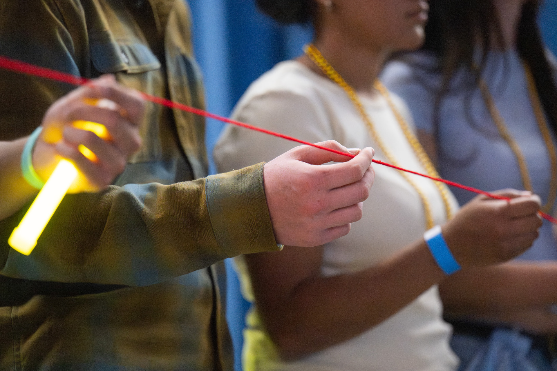 Participants holding a red string during a dance marathon ceremony
