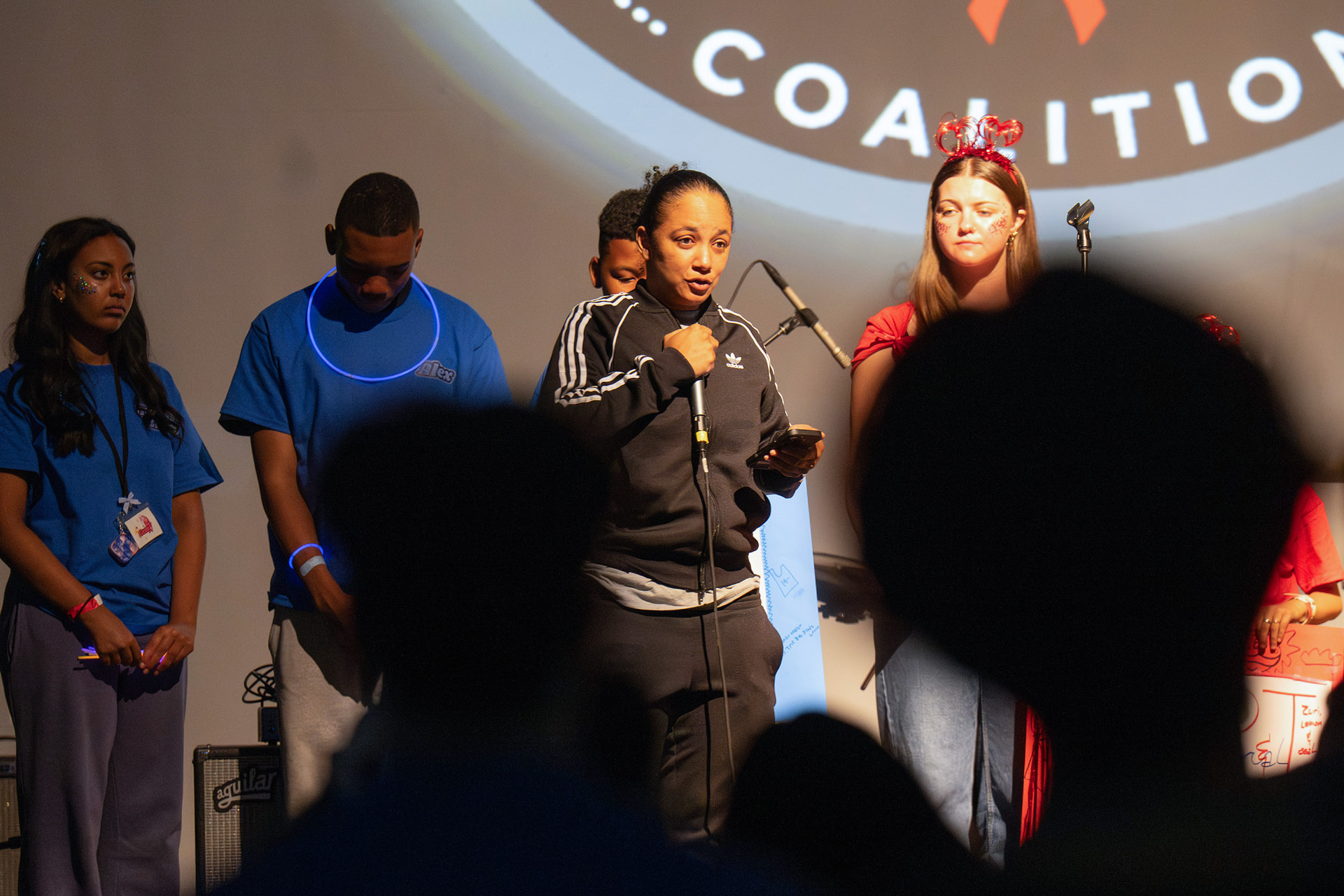 Speaker addressing the crowd on stage at a dance marathon