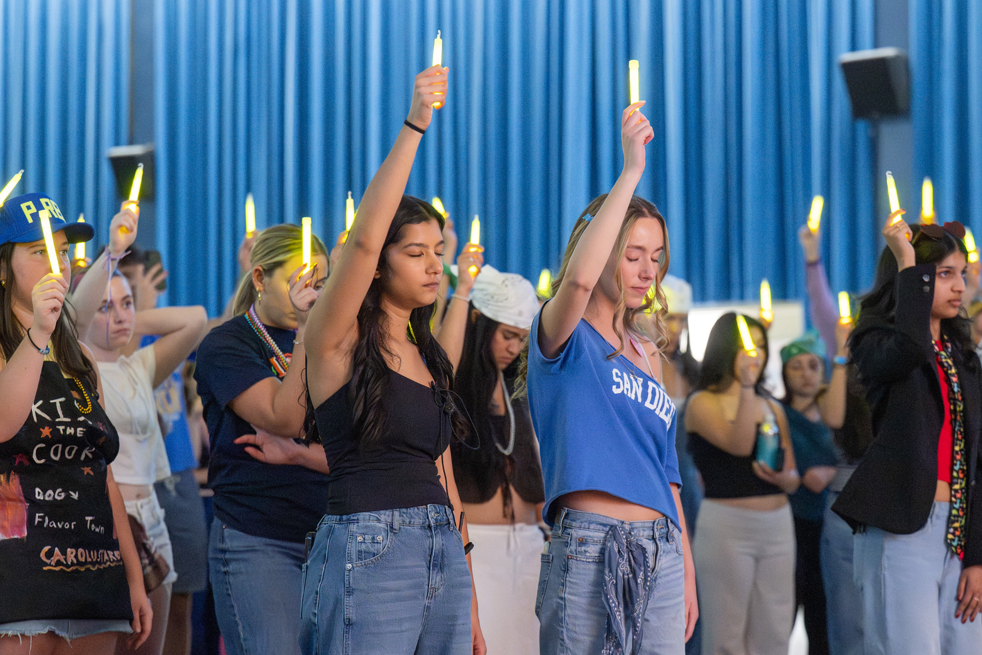 Students raising glow sticks during a moment of silence