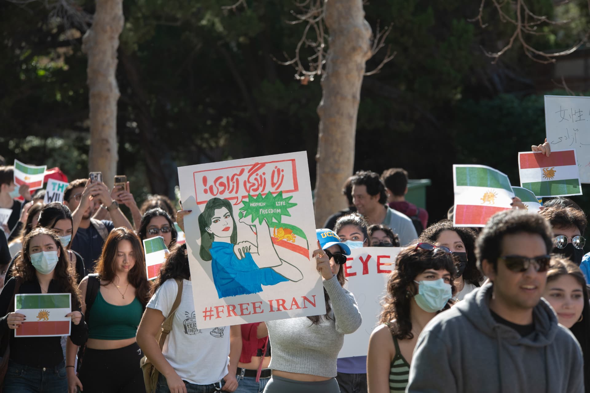 Marcher holding a Women Life Freedom sign at a campus protest