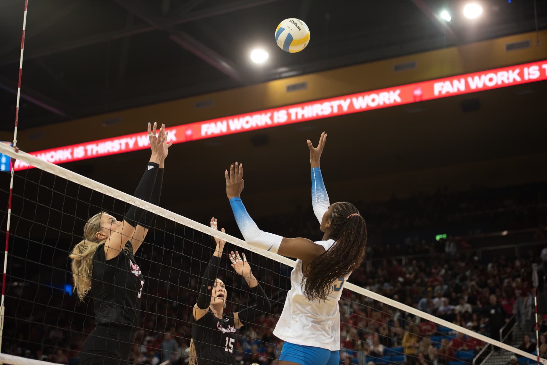 Volleyball players contesting a ball at the net