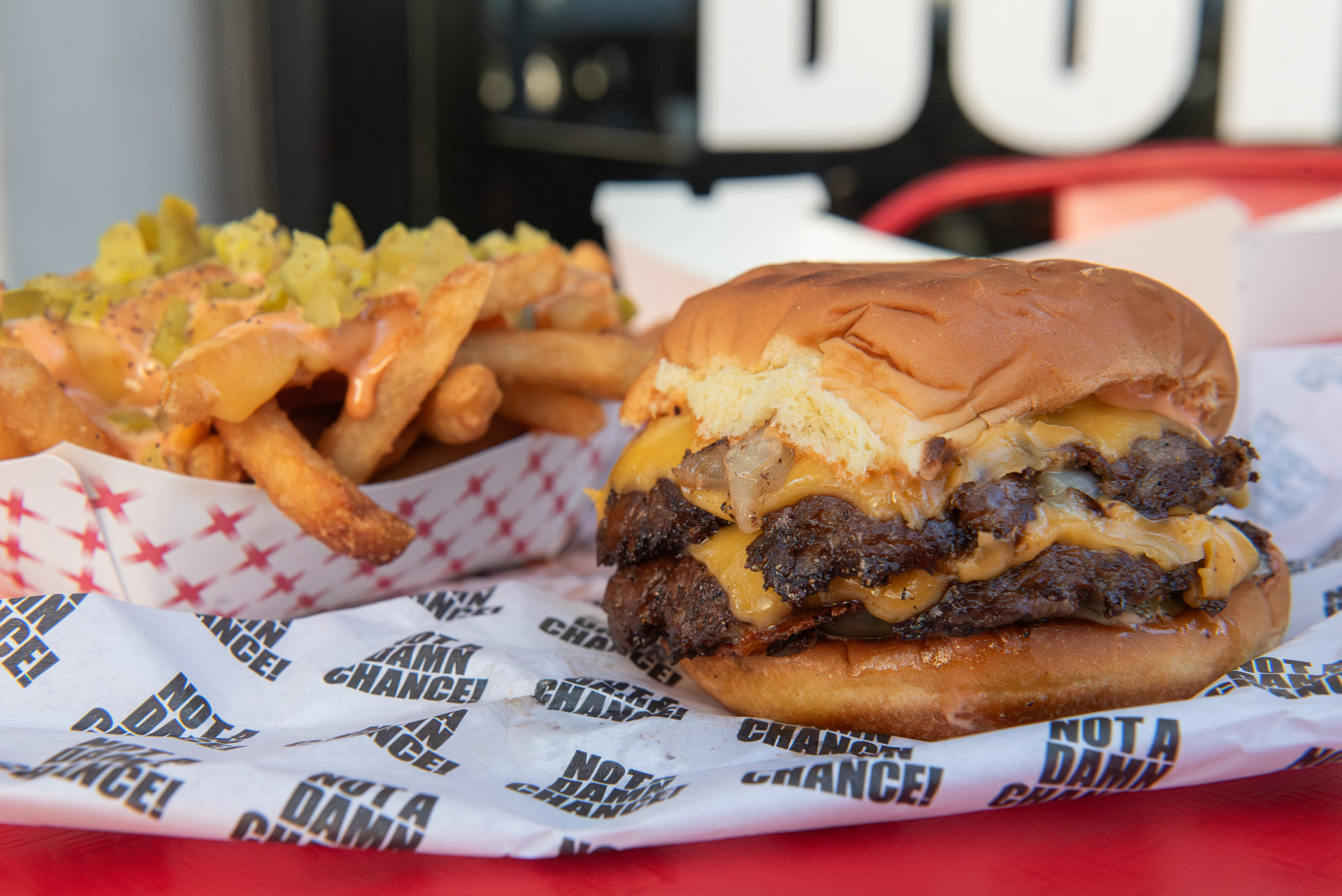 Double cheeseburger and fries on branded wrapping paper