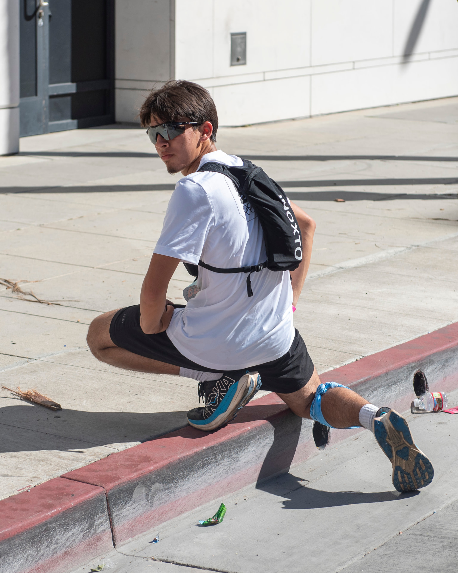 Runner stretching on a curb after the marathon